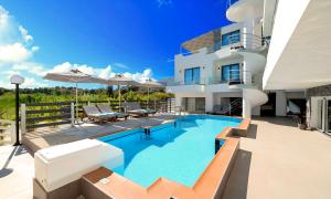 ein Swimmingpool vor einem Haus in der Unterkunft Pnoe Beachside Living in Georgioupoli