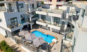 eine Luftaufnahme eines Gebäudes mit einem Swimmingpool in der Unterkunft Pnoe Beachside Living in Georgioupoli