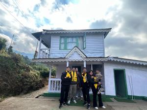 a group of people standing in front of a house at Mim Tea Estate Residency A 1920 Heritage Darjeeling Tea Garden Home in Sukhia Pokhari +8 photos