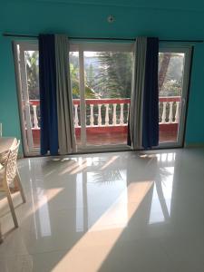a living room with a window and a balcony at Casa De D'souza in Mandrem