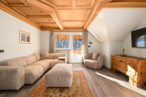 ein Wohnzimmer mit Sofa und Fernseher in der Unterkunft Wellness Residence Villa Leck in Wolkenstein in Gröden