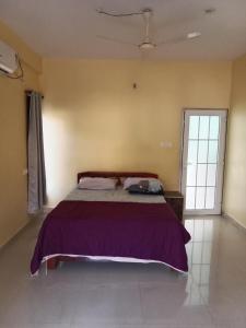 a bedroom with a bed with a purple blanket at Casa De D'souza in Mandrem