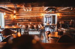 a restaurant with wooden walls and tables and chairs at Hemavans Wärdshus in Hemavan