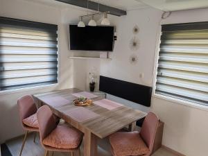 a dining room with a wooden table and chairs at EMIA Family House Čatež in Brežice