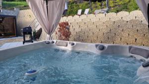 a jacuzzi tub in a backyard with a wall at Noszvaj Vendégház in Noszvaj