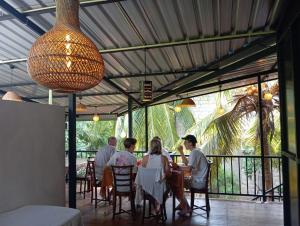 a group of people sitting at a table in a restaurant at Liyana Holiday resort in Anuradhapura