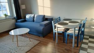 a living room with a blue couch and a table at Apartamenty Rudzka in Rybnik