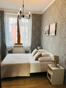 a bedroom with a large bed and a window at Apartamenty Roztocze in Zwierzyniec