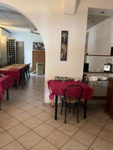 a restaurant with red tables and chairs in a room at La Locanda del Re in Crevalcore