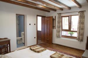 a bedroom with a bed and a window and a toilet at Guest house Zlateya in Madara +30 photos
