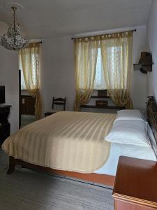 a bedroom with a large bed and two windows at La Corte dei Nonni in Vanzaghello