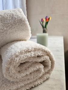 a white towel on a table with a vase of flowers at La Corte dei Nonni in Vanzaghello +22 photos