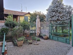 a garden with an open gate and an umbrella at La Corte dei Nonni in Vanzaghello