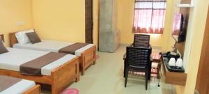 ein Schlafzimmer mit zwei Betten und einem Tisch und Stühlen in der Unterkunft Diamond Blue Residency in Durgapur + 1 Foto