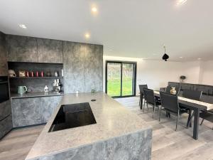 a kitchen and dining room with a table and chairs at Calcedonia House - Gerês in Terras de Bouro