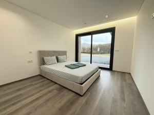 a bedroom with a bed and a large window at Calcedonia House - Gerês in Terras de Bouro