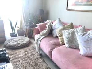 a living room with a pink couch with pillows at Loft independiente Casa Altavista in Valparaíso