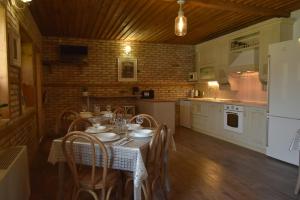 a kitchen with a table with chairs and a refrigerator at Guest house Zlateya in Madara
