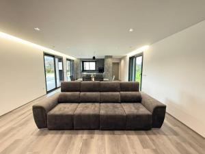 a large living room with a large brown couch at Calcedonia House - Gerês in Terras de Bouro