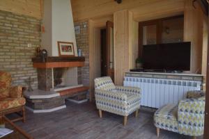 a living room with a fireplace and a tv at Guest house Zlateya in Madara