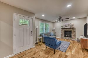 ein Wohnzimmer mit einem blauen Stuhl und einem Kamin in der Unterkunft Spacious 5BR Home Sleeps 9 Modern Comfort in Jonesborough