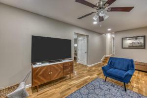 ein Wohnzimmer mit einem Flachbild-TV und einem blauen Stuhl in der Unterkunft Spacious 5BR Home Sleeps 9 Modern Comfort in Jonesborough