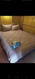 Una cama blanca con una toalla encima. en Bambu hut, en Phra Ae beach