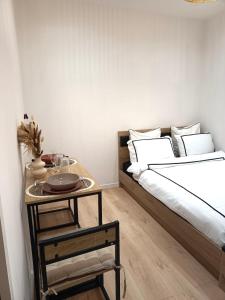 una camera da letto con un letto e un tavolo con un piatto sopra di Studio Luz a Bois-Colombes