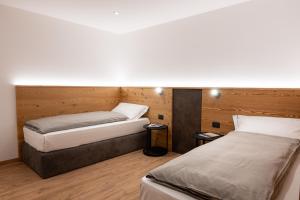 zwei Betten in einem Zimmer mit Holzwänden in der Unterkunft Le Sort Mountain Retreat in Passo del Tonale + 244 Fotos