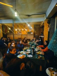 a group of people sitting around a table eating at Shiva Valley Riverside in Jibhi