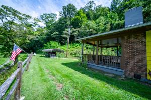 een huis met een hek en een Amerikaanse vlag bij Dragon's Lair in Robbinsville