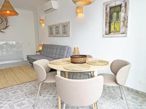 a living room with a table and chairs and a couch at Casa Alice - Olhão By Junto ao Mar in Olhão