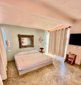 Acogedor estudio con piscina في كانكون: غرفة نوم بها سرير ومرآة على الحائط