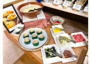 青森青森グリーンパークホテル的一张桌子,上面放有寿司和其他食物