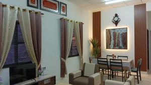 a waiting room with a table and chairs and a tv at Aahana Homestay in Merlimau