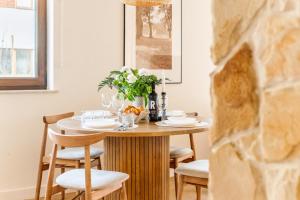 a dining room table with chairs and a vase of flowers at Wino&Grono Nałęczów in Nałęczów