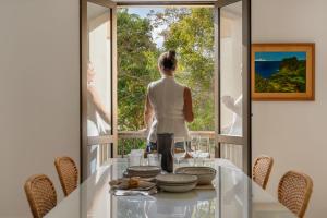 a woman looking out the window of a house at Baía II by An Island Apart in Funchal