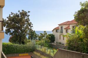 a house with the ocean in the background at Baía II by An Island Apart in Funchal