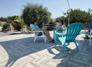 een man en een vrouw zitten aan een tafel bij Villa del Marinaio in Mazara del Vallo