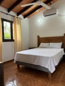 Un dormitorio con una cama blanca en una habitación. en Los Cantares, en Piribebuy