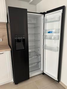 Ferienhaus nah der Ostsee, 110qm mit eigenem Garten في شاربوتس: ثلاجة سوداء بابها مفتوح في مطبخ