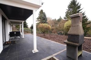 Ferienhaus nah der Ostsee, 110qm mit eigenem Garten في شاربوتس: شرفة منزل مع تمثال حجري