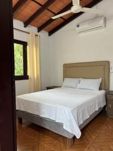 Un dormitorio con una gran cama blanca con techo. en Los Cantares, en Piribebuy 33 fotos más