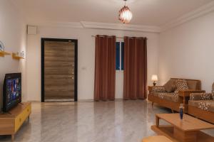 Una sala de estar con un sofá y un televisor. en Elegant Villa with Private Pool in South Hammamet 2P, en Hammamet Sud