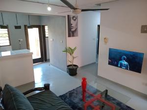 a living room with a couch and a tv on a wall at TN apartments voism in Diani Beach