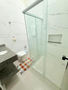 a bathroom with a glass shower and a toilet at Espaço aconchego a 3 minutos do centro in Sinop