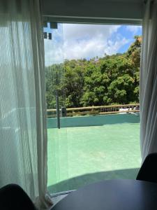 uma vista de uma quadra de tênis através de uma janela em Casa com area verde 2 quartos em São Miguel dos Milagres