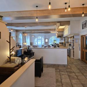 a large kitchen with a counter and a bar at LA MAISON Crêperie-Bar-Hôtel in Le Valtin