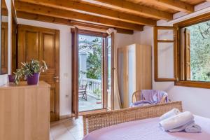 a bedroom with a bed and a window with a patio at Μeropi & Natalia Villas in Skopelos Town +31 photos