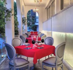 a long table with red table cloth and chairs on a patio at Coelho Boutique Hotel in Gatteo a Mare